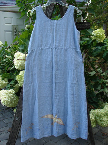 1999 Handkerchief Linen Sunbeam Dress Love Dove Water Altered Size 1 hanging on a clothesline, showcasing its flared lower design and empire waist seam.