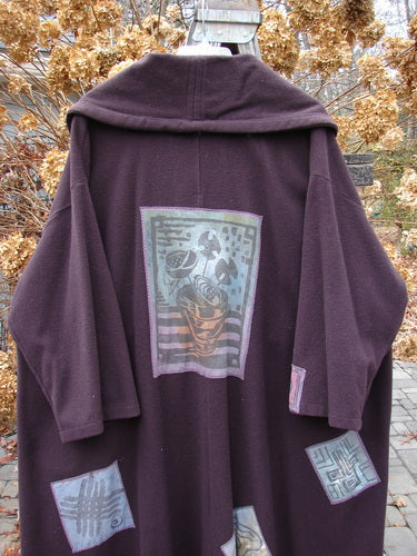 1994 Patched Wool Falling Snow Coat Plum Wine OSFA featuring a richly textured purple design, adorned with multi-colored patches and vintage buttons, oversized shawl collar, and deep front pockets.