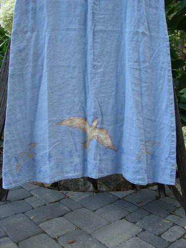 1999 Handkerchief Linen Sunbeam Dress Love Dove Water Altered Size 1 hanging on a clothes rack, showcasing its lightweight linen fabric and bright paint in the Love Dove theme.