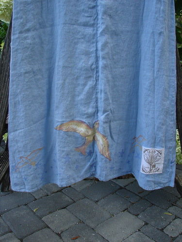 1999 Handkerchief Linen Sunbeam Dress Love Dove Water Altered Size 1 featuring bright bird-themed paint, short fall, and flared lower section, displayed on a brick walkway.