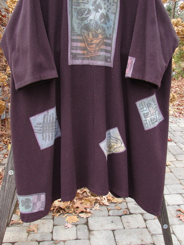 1994 Patched Wool Falling Snow Coat Plum Wine OSFA, adorned with multicolored patches, features a shawl collar, vintage buttons, deep pockets, and a flared shape for a cozy, vintage look.