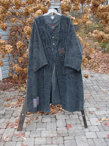 2000 Patched Upholstery Diwmach Coat Swirl Black Size 2 displayed on a hanger, showcasing its damask swirl pattern, colorful patches, large front pocket, scalloped neckline, and belled sleeves.