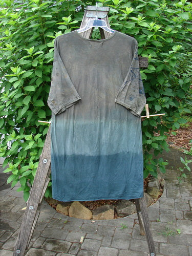 Barclay Tournesol Slim Tunic Sea Botanicals Mottled Brown Ocean OSFA hanging on a clothesline, showcasing its unique longer tunic length, drop shoulders, and varying hemline against an outdoor backdrop.
