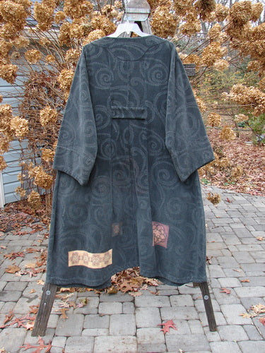 2000 Patched Upholstery Diwmach Coat Swirl Black Size 2 displayed on a hanger, showcasing its damask pattern, colorful patches, large pocket, and vintage buttons with belled sleeves and an A-line shape.