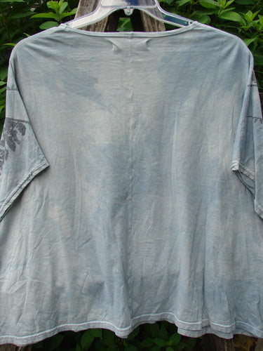 Barclay Cricket Cap Sleeve Tee Pine Forest Blue Dawn OSFA displayed on a clothes rack, highlighting its seamless shoulder sleeve, cap sleeves, and square boxy shape, embodying Bluefishfinder.com's vintage creative expression.