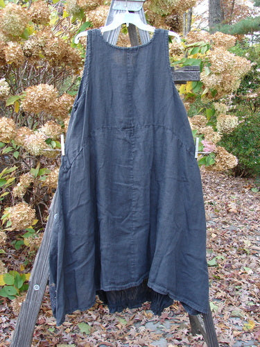 Barclay Linen Open Front Drawcord Hem Jumper with a layered crossover front, elastic gathered hemline, and a deeper oval neckline displayed on a wooden ladder.