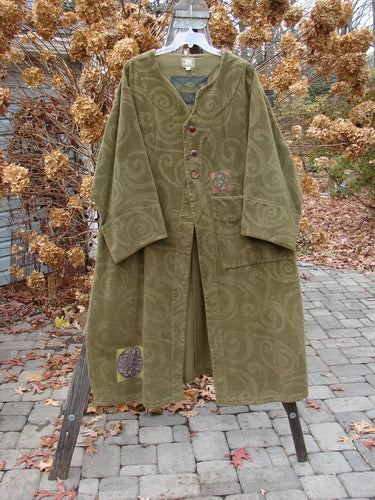 2000 Patched Upholstery Diwmach Coat in Pine, Size 2. Luxurious heavy-weight cotton with damask swirl pattern. Scalloped neckline, vintage buttons, belled sleeves, A-line shape, pleated rear. Rich texture and weight. Bust 54, Waist 54, Hips 62. Length: 50 inches in front, graduated in back. Cuffed and belled sleeves: 28 inches.
