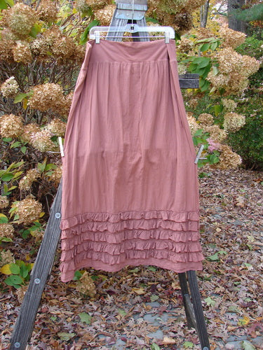 Barclay NWT Voile Foldover Five Ruffle Skirt Unpainted Kiss Cliff Size 2 displayed on a wooden stand, showcasing its ruffled hemline and billowy A-line shape.