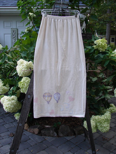 1999 Straight Skirt Air Balloon Natural Size 0 on a wooden ladder, showcasing its full elastic waistband, straight shape, and hot air balloon-themed hem from Bluefishfinder's vintage collection.