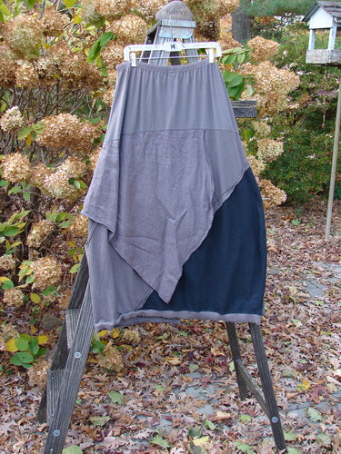 Barclay Mixed Media Swatch Skirt on a rack, showcasing its layered design, sectional panels, and elastic waistline, emphasizing the intricate textures and dimensional styling.