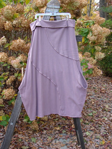 Barclay Cotton Lycra Fold Over Lantern Skirt Stripe Plum Size 2 displayed on a wooden ladder, showcasing its unique fold-over cross-paneled waistline and curvy S-shaped exterior stitchery.