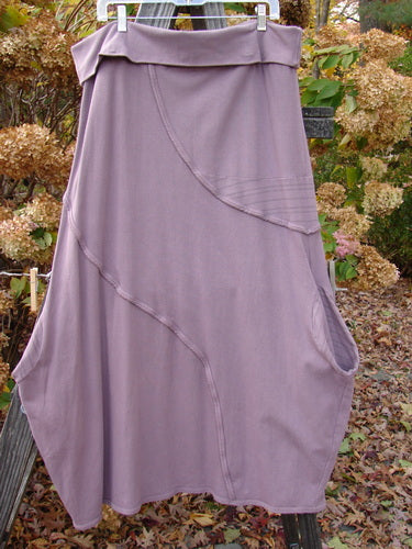 Barclay Cotton Lycra Fold Over Lantern Skirt Stripe Plum Size 2 displayed outdoors on a wooden post, highlighting its cross-paneled waistline and curvy exterior stitchery.