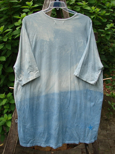 Barclay Tournesol Tunic Flower Power Mottled Day Sky OSFA, featuring a close-up of its loose three-quarter sleeves and unique hemline, showcasing the signature Blue Fish Clothing style.