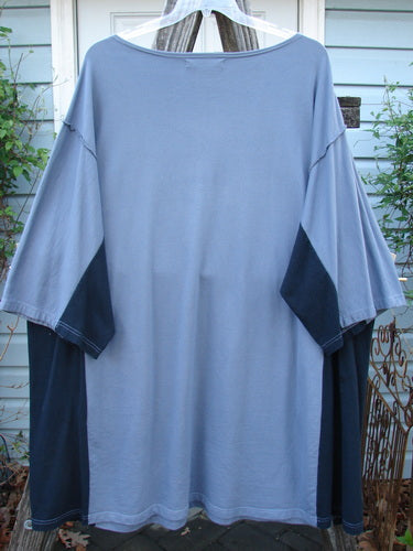 Barclay Cotton Interlock Contrast Side Panel Tunic Scenic Travel Sky Black Size 2 displayed on a clothes rack, showcasing its wide sleeves, boatneck neckline, and distinctive contrasting side panels.