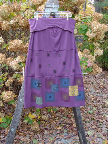 Barclay Patched Thermal Fold Over Pencil Panel Skirt Grid Stripe Magenta Size 2 displayed on a wooden stand, featuring a fold-over waist, horizontal stitchery, tiny patches on the hem, and lettuce edge.