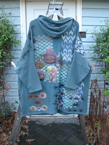 Barclay Fleece Hooded Zip Pocket Jacket Equestrian Light Love Mirror Size 3 displayed on a wooden rack, featuring a cozy hood, dolman shoulders, and equestrian-themed prints with a kangaroo pocket.