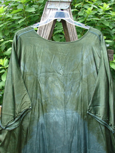 Barclay Viscose Vitreous High Low Tunic Botanicals Mottled Forest Sun OSFA displayed on a swing, showcasing its rounded neckline, varying hem, and three-quarter dolman sleeves with exterior stitchery.