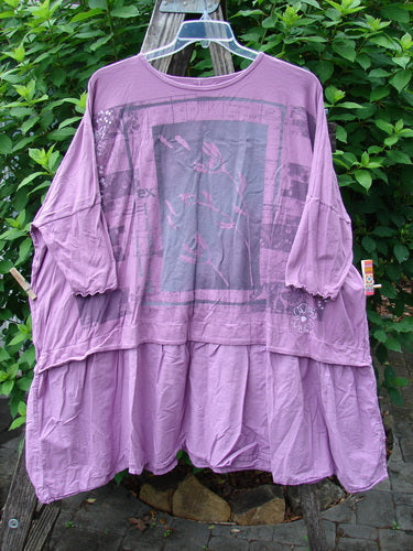 Barclay Batiste Banded Flounce Esperanza Tunic Sprig Crocus OSFA, showcasing dolman sleeves and a rounded neckline, hangs elegantly on a clothes rack, embodying Bluefishfinder.com's vintage-inspired style.