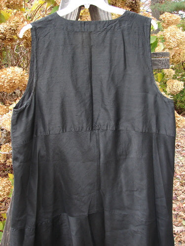 2000 Shaunting Silk Layering Jumper Unpainted Black Size 2, displayed hanging on a wooden fence, showcasing a deep V-neckline, sectional panels, and drop rear waistline.