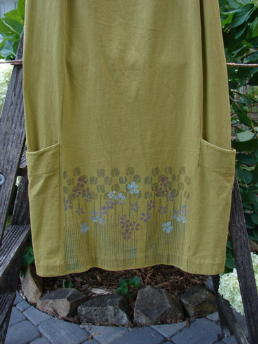 2000 Leaflet Skirt Garden Peapod Altered Size 0: A green skirt with a floral design, featuring a slightly tapered hemline, wrap-around lower drop pockets, and a full elastic waistband.