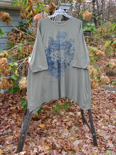 Barclay Three Quarter Sleeved Cafe Tunic Pansy Light Moss Size 2, displayed on a rack, features a blue design. Part of Bluefishfinder.com's vintage collection, it embodies creative expression and individuality.