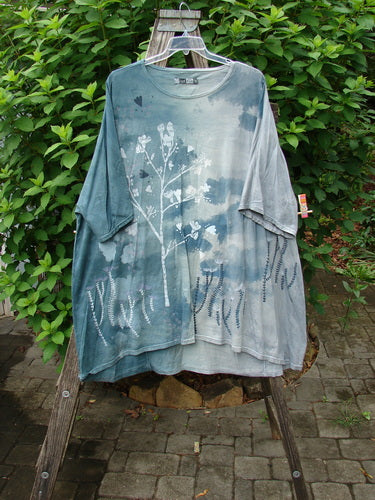 Barclay Art Tee Bud Rise Mottled Green Storm OSFA features a tree design on a blue shirt, with drop shoulders, loose sleeves, and a varying hemline, embodying Bluefishfinder's vintage aesthetic.