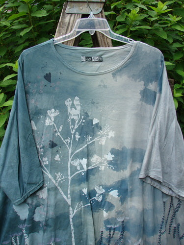 Barclay Art Tee Bud Rise Mottled Green Storm OSFA features a mottled green floral design, loose three-quarter sleeves, and a longer tunic length with a unique varying hemline.