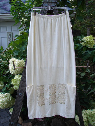 2000 Leaflet Skirt Garden Gates Milk Size 1, featuring a dynamic slightly tapered hemline, billowy wrap-around sectional lower drop pockets, and a detailed colorful garden gate theme paint on front and back.