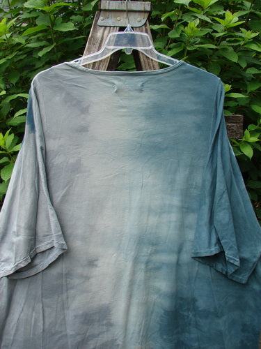 Barclay Art Tee Bud Rise Mottled Green Storm OSFA displayed on a plastic swinger. Features include a tunic length, drop shoulders, three-quarter sleeves, and a rounded neckline with a floral theme.