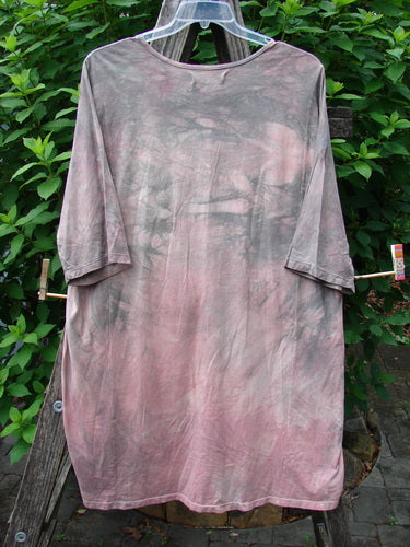 Barclay Tournesol Tunic Bunny Field Mottled Mauve OSFA displayed on a clothesline, showcasing its drop shoulders, loose three-quarter sleeves, and varying hemline, with a bunny theme pattern visible.