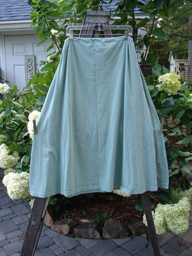 1994 Scoop Pocket Skirt Garden Fish Aloe Size 1 displayed on a clothes rack, featuring a drawstring waist, two front scooped painted pockets, and an A-line shape with a sweeping hem.