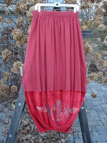 1996 Velvet Arrowhead Sofia Duo Pomegranate Size 1 displayed on a wooden stand, showcasing the bell-shaped upper skirt with velvet trim and pegged lower shape, highlighting its elegant, vintage design.