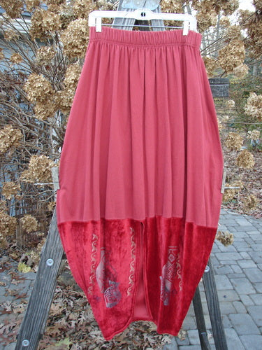 1996 Velvet Arrowhead Sofia Duo Pomegranate Size 1: A red skirt displayed on a wooden stand, showcasing its bell-shaped upper, velvet accents, pegged lower shape, and deep pockets.
