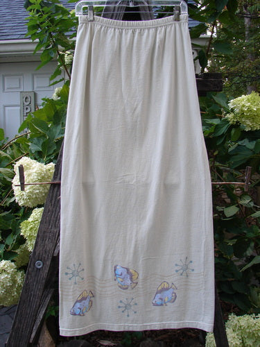 1999 Straight Skirt Fish School Dust Size 0, displayed on a wooden ladder, showcasing its full elastic waistband and straighter shape adorned with a painted fish school theme around the hem.