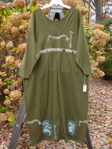 1993 NWT Holiday Button Maker's Dress Roman Goddess Olive OSFA displayed on a wooden rack, featuring a deep V neckline, vintage buttons at the waist, and vertical draw cords at the hem.