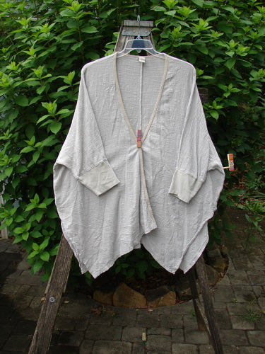 Barclay Gauze Open Front Cardigan Unpainted Natural Size 2 displayed on a swinger highlights its dolman sleeves, open front, and vented sides, embodying BlueFishFinder's vintage, expressive style.