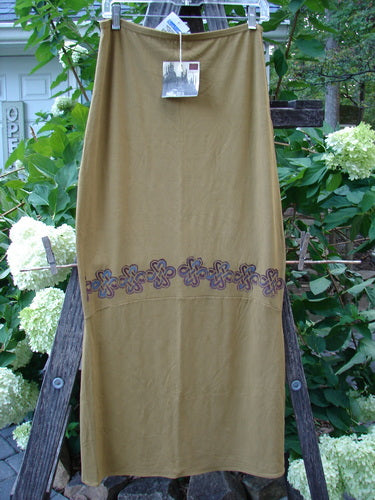2000 NWT Rayon Lycra Narrow Skirt Celtic Celebration Bone Size 2, displaying a long hourglass shape with a blue and purple floral pattern, hanging on a clothesline outdoors.
