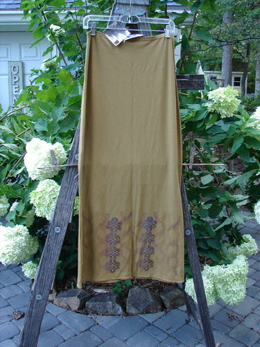 2000 NWT Rayon Lycra Narrow Skirt Celtic Celebration Bone Size 2 displayed on a wooden ladder, showcasing its long hourglass shape, horizontal sectional panels, and full thinner flattened elastic waistband.