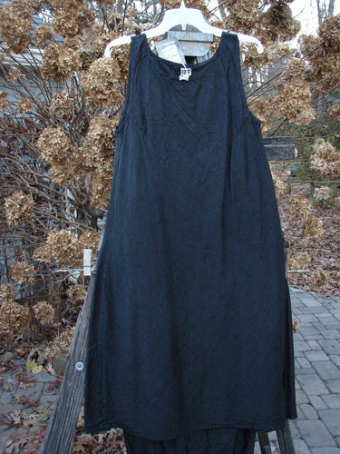 2000 Signed by Jen Shaunting Silk Gather Duo Spin Size 1: A black dress on a clothes rack, with a blue dress nearby.