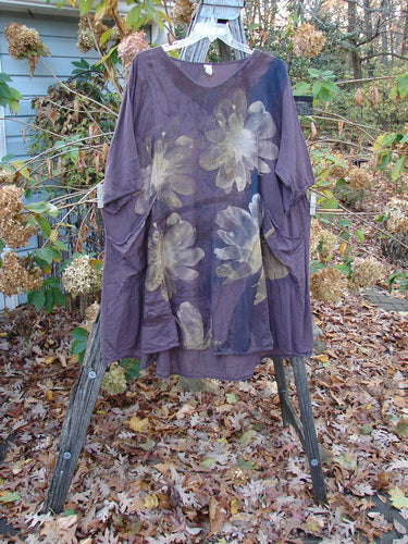 Barclay Linen Drawback Pocket Tunic Golden Daisy Plum Size 2, featuring a floral pattern, displayed on a wooden ladder. Light weight, short-sleeved, perfect for expressing individuality through vintage-inspired style.