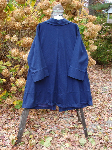 Barclay Denim Triangular Collar Coat Unpainted Royal Size 2 displayed on a stand, featuring a full button front, A-line shape, banded sleeves, and diagonal paneled pockets.