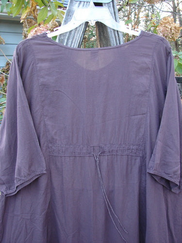 Barclay Linen Drawback Pocket Tunic Golden Daisy Plum Size 2 displayed on a clothes hanger, showcasing its lightweight, short-sleeved design and unique drawbacks, reflecting BlueFishFinder's vintage aesthetic.