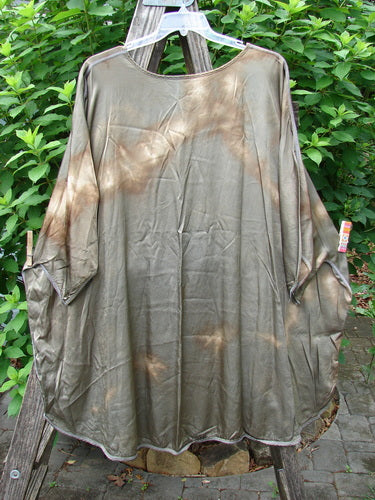 Barclay Viscose Vitreous High Low Tunic Botanicals Mottled Copper Bronze OSFA displayed on a clothes rack, showcasing its rounded neckline, three-quarter dolman sleeves, and varying hem with exterior stitchery.