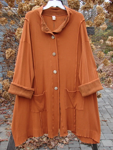 Barclay Thermal Mock Collar Coat Mixed Media Pumpkin Size 2 displayed on a hanger, featuring large wooden buttons, a stand-up mock turtleneck collar, wide sleeves, and exterior rolled piping.