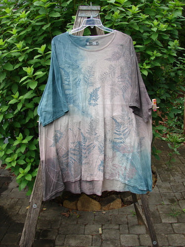 Barclay Art Tee Fern Garden Mottled Pure Dawn OSFA displayed on a hanger, showcasing its tunic length, drop shoulders, loose three-quarter sleeves, rounded neckline, and artistic spring garden print.
