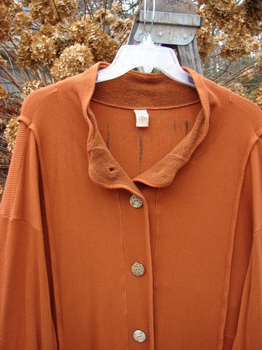 Barclay Thermal Mock Collar Coat Mixed Media Pumpkin Size 2, featuring a close-up of wide longer sleeves, wooden buttons, and a stand-up mock turtleneck collar with exterior rolled piping.