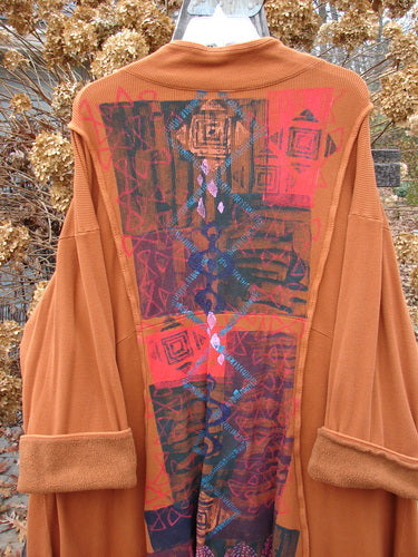 Barclay Thermal Mock Collar Coat in Pumpkin with wide sleeves, exterior rolled piping, wooden buttons, and a sweeping A-line shape. Features graphic arts paint on the back.