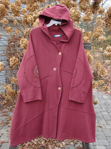 Barclay Patched Interlock Hooded Curve Coat Red Wine Size 2 displayed on a hanger, showcasing its cozy hood, giant circle sleeve patches, S-shaped button line, and A-line flair.