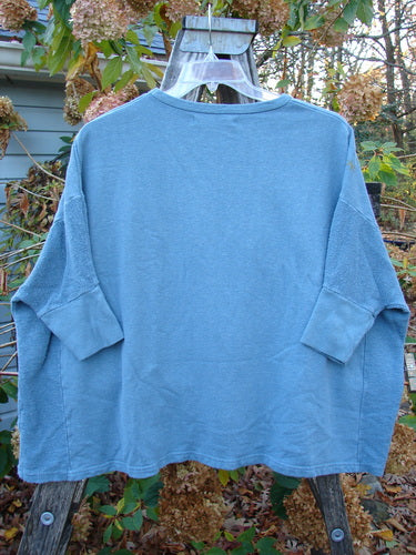 Barclay Hemp Cotton Banded Sleeve Dolman Top Mum Blue Dusk OSFA displayed on a hanger, highlighting its heavy-weight fabric and unique banded sleeves, embodying the vintage and creative spirit of Blue Fish Clothing.