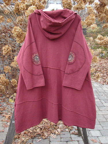 Barclay Patched Interlock Hooded Curve Coat Red Wine Size 2 on a clothes rack, showcasing a cozy hood, giant circle sleeve patches, and a sweeping A-line flair with exterior stitchery.